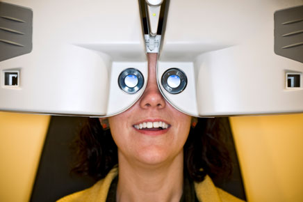 photo: woman having vision checked in automated Phoropter